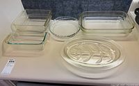 All six Pyrex glass cookware and serveware pieces on a countertop showing different shapes and sizes.