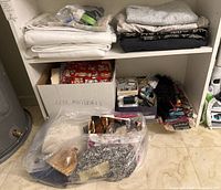 Folded assorted fabrics, leather materials box, sewing threads and notions under shelving unit