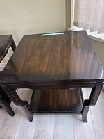 Top view of solid wood side table showing smooth dark brown finish with lighter wood grain visible.