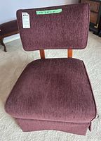 Front view of the upholstered chair showing burgundy fabric on seat and backrest with wooden supports