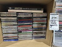 Photo of boxed collection of CDs stacked in four columns including Johnny Cash 3 CD Set with bonus DVD
