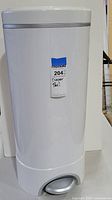 Front view of white Munchkin Step Diaper Pail showing foot pedal and label