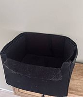 Front angled view of black fabric car pet carrier showing padded sides and open top