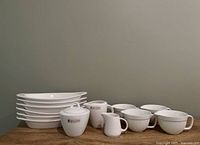 Full lot showing six au gratin dishes, sugar bowl, two creamers, four mugs