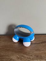Front angle of the blue Homedics mini massager showing four white nodes and oval body
