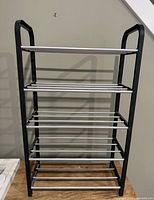 Full view of 4-tier shoe rack on wooden surface