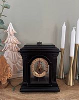 Front view of black Bombay mantel clock showing dial and case details