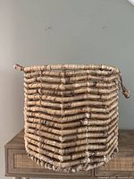 Side view of wicker basket showing coiled construction and slight wear at bottom