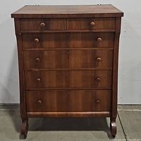 Front view of oak highboy dresser showing six drawers and turned wooden knobs