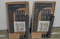 Pair of metal bracket kits packaged on cardboard with clear plastic, showing brackets and included hardware sets