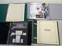 Millennium Limited Edition Collection Book by Canada Post, binder in gray cover and additional binders containing assorted stamps on black and green album pages.