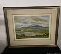 Framed landscape watercolour painting with silver-toned frame showing minor imperfections on frame edges.