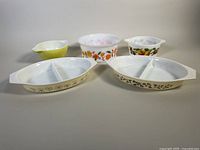 Overview of all five casserole dishes including two divided Pyrexware and three milk glass casseroles