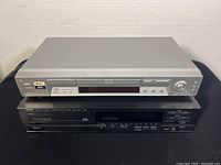 Sony DVP-NS715P DVD/CD player stacked on top of Yamaha CDX-510U CD player showing front panels and size comparison.