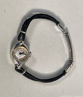 Full view of ladies Bulova wristwatch showing gold case and black braided cord band