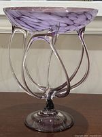 Side view showing the purple mottled bowl supported by clear curved glass tentacle-like structures and solid base.
