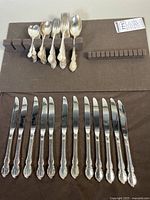 Photo showing collection of knives, forks, spoons arranged on felt flatware board, showing condition and style.