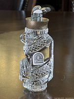 Crystal golf bag paperweight with metal golf clubs and textured metal rim at top