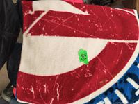 Folded fleece blanket showing the red and white pattern with a green price sticker.