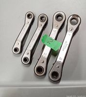 Four Mastercraft box end ratchet wrenches laid out side by side, sizes 8, 10, 12, and 14 mm visible, with a green sticker marked '20' placed above the 12mm wrench.