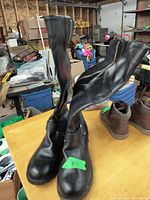 Black mid-calf ladies winter boots with inside zipper, showing one boot upright and one tilted to display zipper and details