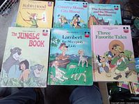 Photo showing six Walt Disney collectible books with illustrated covers showing classic characters.