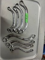 Eight chrome double box-end metric wrenches laid out on a plastic surface showing different sizes and Craftsman brand embossing