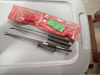 Three Ullman lock pick tools and original translucent red plastic carrying case