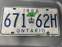 Photo of vintage 1968 Ontario license plate with visible wear and minor damage on one corner.