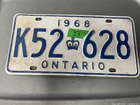 Front view of the 1968 Ontario license plate with blue text and crown symbol, used condition.