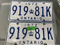 Pair of vintage 1972 Ontario license plates showing the front face of both plates together with visible wear and some dents.