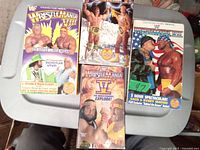 Four VHS tape cases from WWF WrestleMania editions 5, 6, 7, 8 shown from front, featuring colorful wrestler artwork.