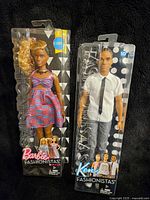 Photo showing Barbie Fashionista doll with curly blonde hair in a colorful dress and Ken Fashionista doll in white shirt and black tie in original packaging