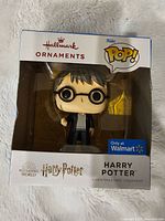 Boxed Funko Pop style Harry Potter ornament with Harry wearing glasses and robe, labeled as Hallmark ornament and exclusive to Walmart.