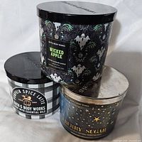 Three Bath & Body Works candles stacked showing labels Wicked Apple, Pumpkin Spice Latte, and Blueberry Sugar