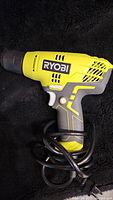 Ryobi electric drill front view showing body, handle, trigger, and cord wrapped around the handle