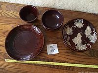 Overview of all items in lot showing 3 dinner plates, 2 cereal bowls, 1 mixing bowl with Rustic Grape luncheon plates