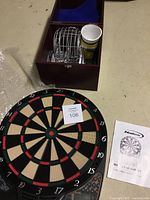Photo of wooden bingo box showing metal number cages, bingo cards, chips, and a plastic spinning bingo wheel