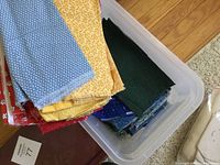 Plastic bin with folded colorful quilting fabric pieces