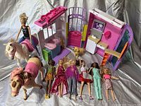 Photo showing six Barbie dolls in front of Barbie Pet Daycare playset including two horses and a small dog figure