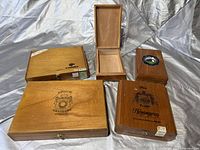 Photo showing five wooden cigar boxes from Cohiba, Hemingway, Punch, Busch Grand Cru and one unbranded opened box