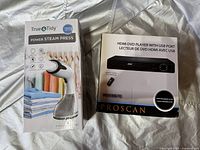 Both boxed items: True & Tidy Power Steam Press and Proscan HDMI DVD Player boxed and unopened.