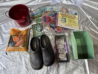 Full view of all gardening items including sandals, potting mix, bucket, seed packets, planter, and garden stakes.
