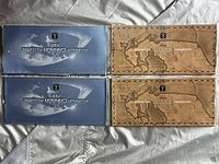 Four coin sets: Two 1999 Millennium Canada in brown map-themed cases, two 2000 Millennium Canada in blue Earth-themed cases seen from above.