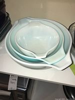 Photo showing three nested Pyrex mixing bowls with Amish Butterprint design in white and blue