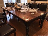 Full view of rectangular wood dining table with decorative glassware