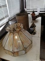 Photo showing large stained glass ceiling light with brass frame and some metal and ceramic parts behind it