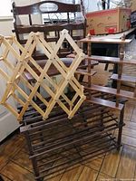 Wooden folding table, wine rack, magazine holder, and small shelves grouped together on wooden floor.