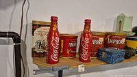 Front shelf view with Coca-Cola bottles and Amphora tins