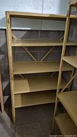 Photo showing front view of metal storage shelf with two shelves, beige color, rust visible on surfaces.